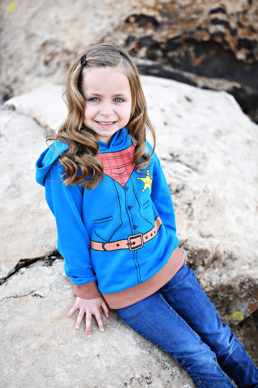 Child wearing blue cowboy costume hoodie with western design