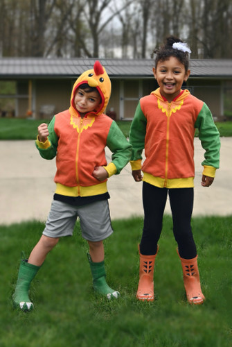 Two children in rooster hoodies outdoors