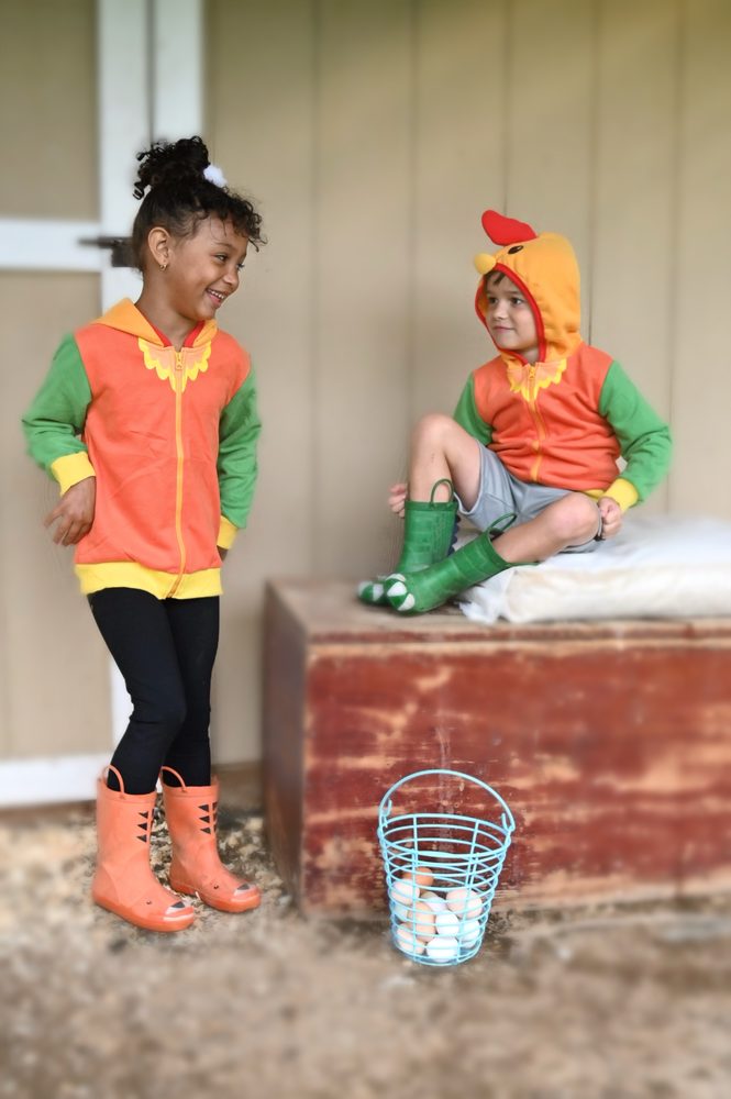 Two kids on a farm porch with an egg basket
