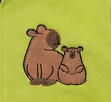 Close-up of embroidered adult and baby capybara pair on green fleece fabric
