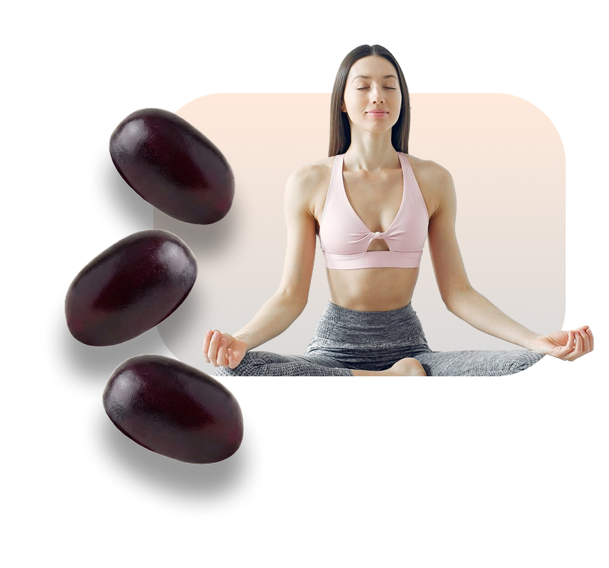 Woman meditating in a seated yoga pose next to green gummy supplements.