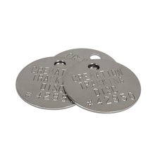 Three Silver metal tracking discs with a hole punched in the top of each and words and number pressed into the metal